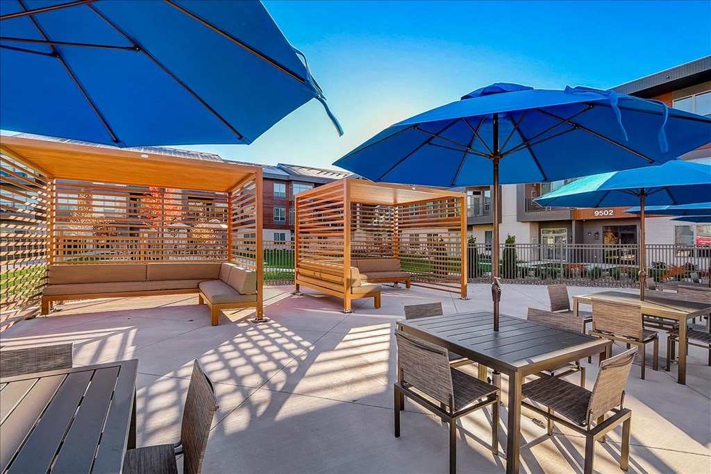 a patio with tables and chairs and umbrellas