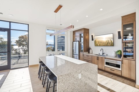 a large kitchen with a marble counter top and a door to a balcony