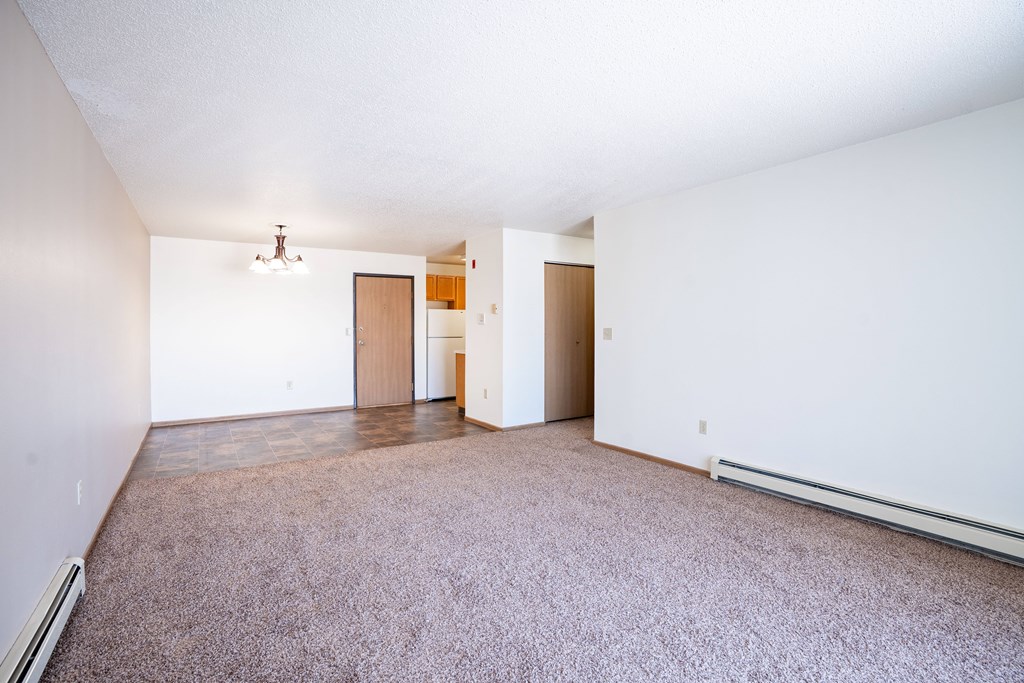 A room with a carpeted floor and a white wall.