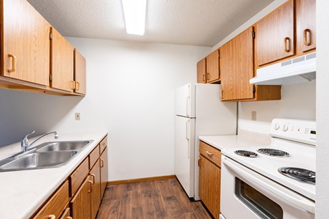 A kitchen with wooden cabinets and white appliances.
