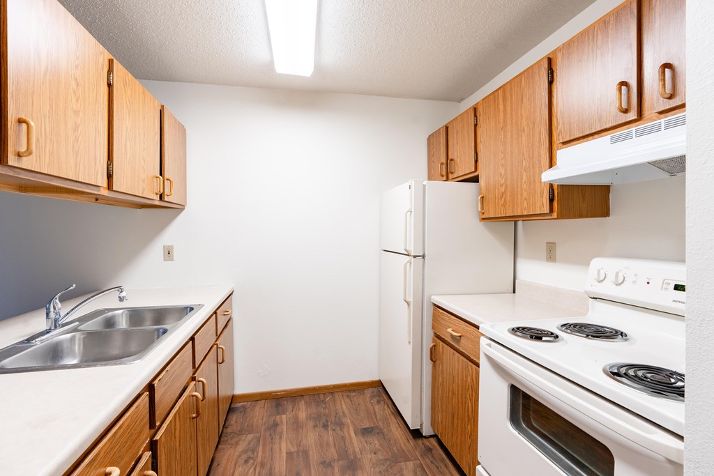 Fargo, ND Candlelight Apartments | 11B | Kitchen A kitchen with wooden cabinets and white appliances. Fargo, ND Candlelight Apartments