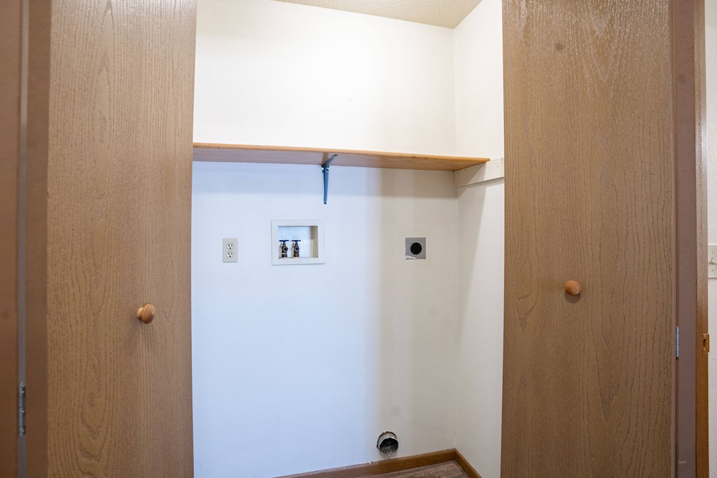 a closet with a shelf and laundry hookups. Fargo, ND Country Edge Apartments