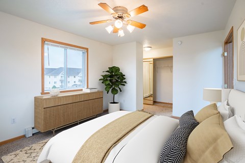 A bedroom with a large bed and a ceiling fan.