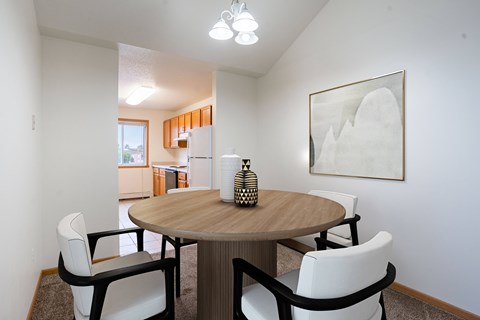 A dining room with a round table and chairs. Fargo, ND Summit Point Apartments