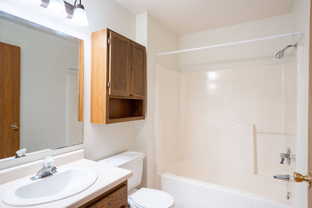 A white bathroom with a sink, toilet and bathtub. Fargo, ND Somerset Apartments