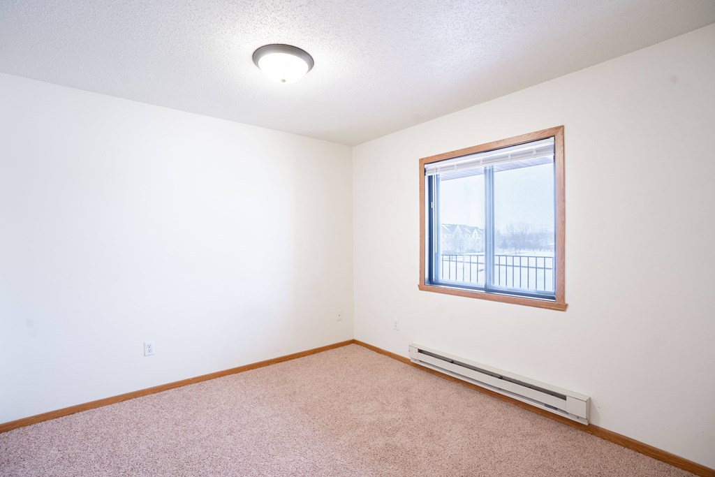 A room with a window and a heater on the floor. Fargo, ND Somerset Apartments