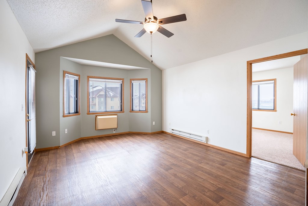 A room with a ceiling fan and wooden floors. Fargo, ND Somerset Apartments