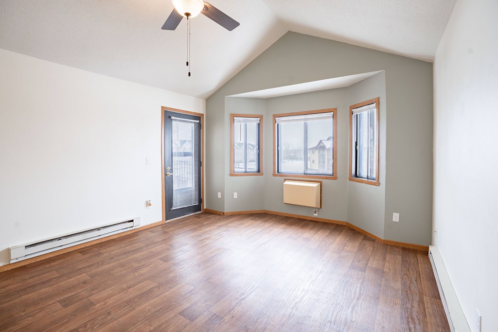 A room with a ceiling fan and three windows. Fargo, ND Somerset Apartments