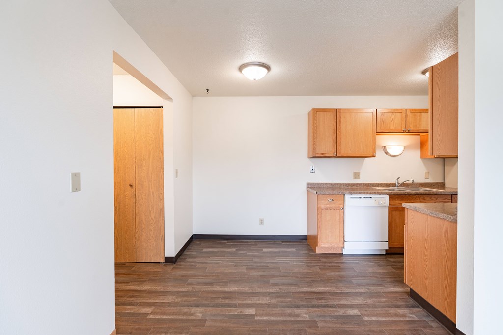 A kitchen with wooden floors and cabinets. West Fargo, ND Saddlebrook Apartments