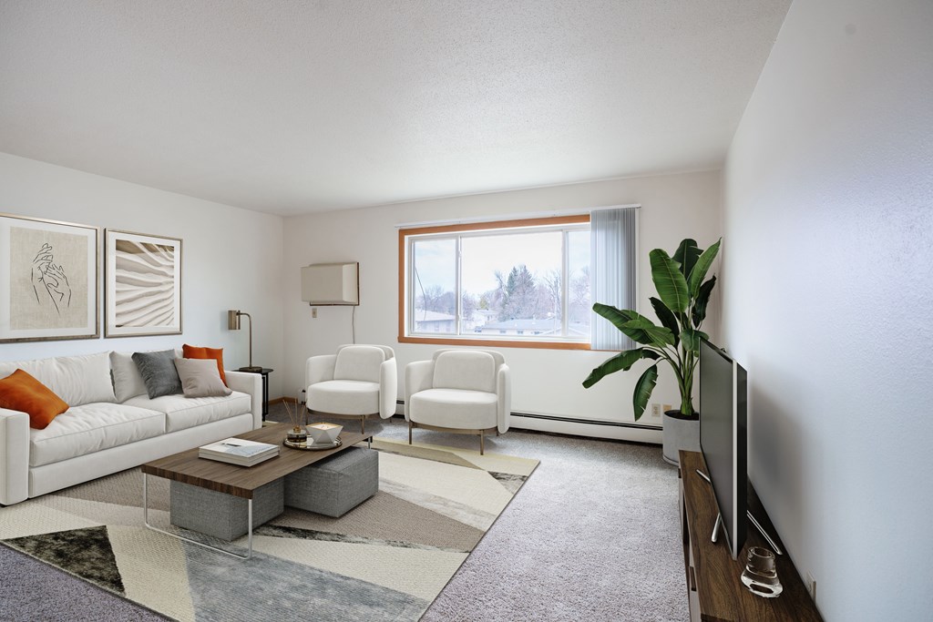 West Fargo, ND Saddlebrook Apartments | 21B | Living A living room with a white couch, two chairs, a coffee table, and a television. West Fargo, ND Saddlebrook Apartments