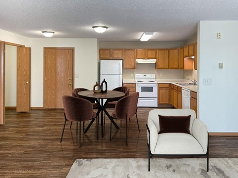 A kitchen with a table and chairs in the foreground.