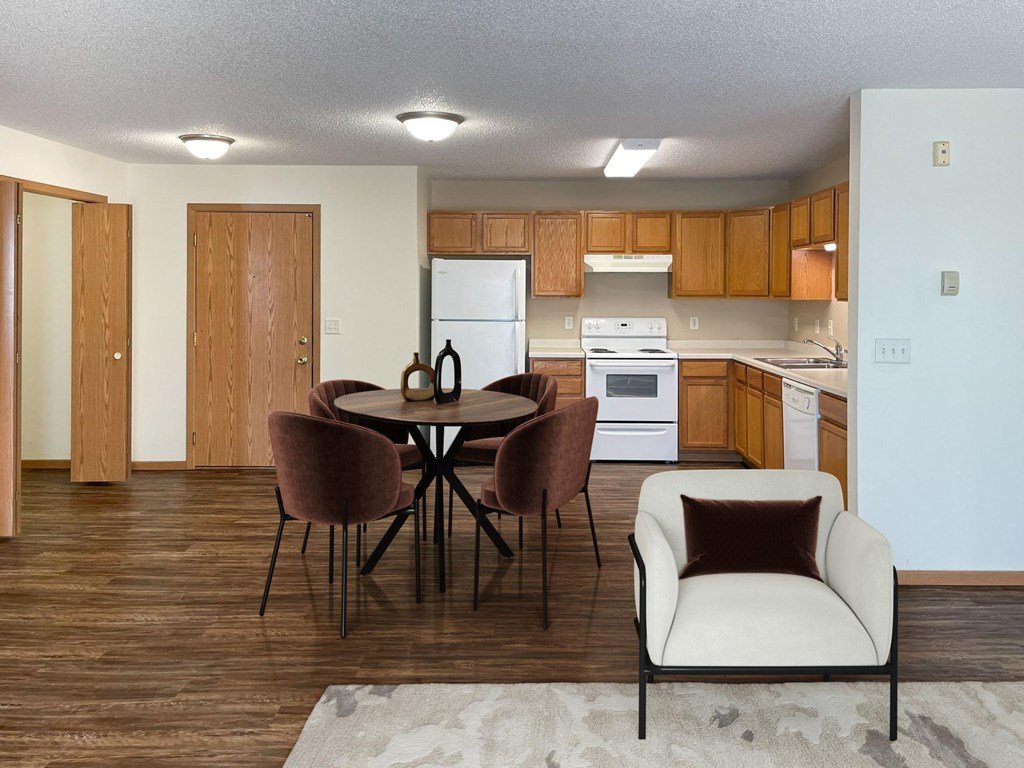 Bismarck, ND Sierra Ridge Apartments | 32B | Dining A kitchen with a table and chairs in the foreground. Bismarck, ND Sierra Ridge Apartments