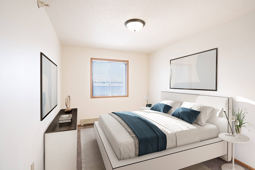 Fargo, ND Fieldstone Apartments | 21A | Bedroom A bedroom with a large bed and a window. Fargo, ND Fieldstone Apartments