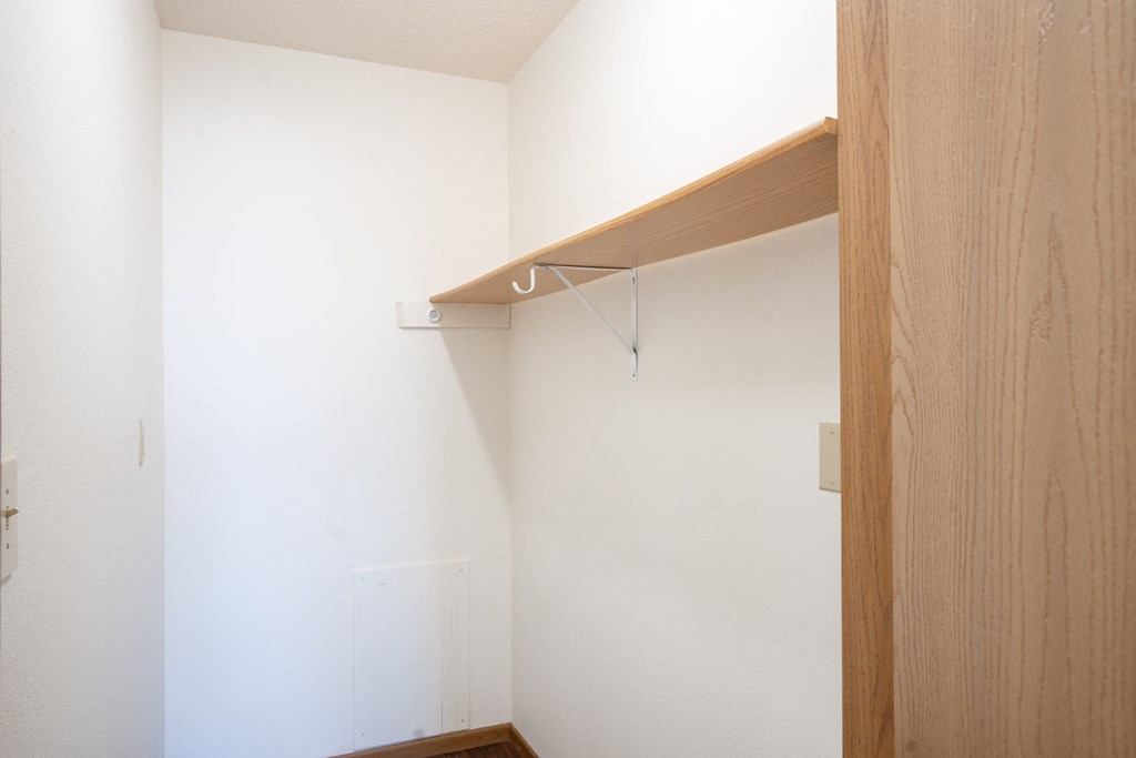 A white wall with a wooden shelf on it. Fargo, ND Fieldstone Apartments