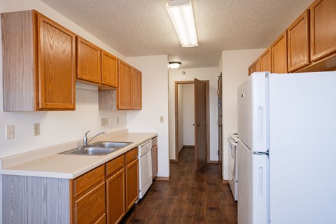 A kitchen with wooden cabinets and a white fridge.