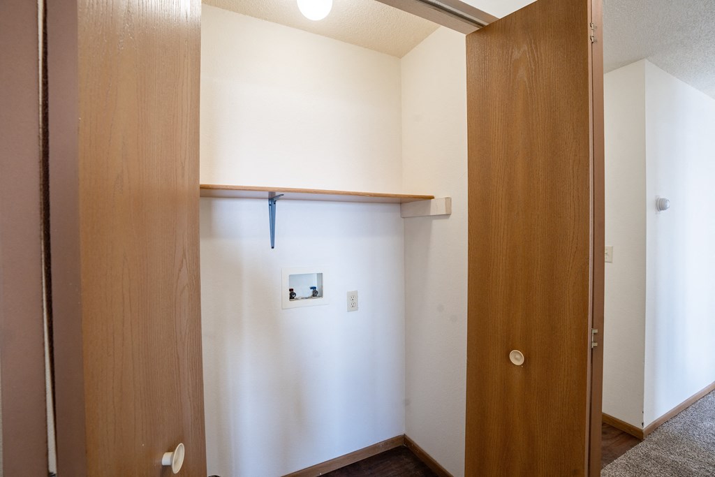 A white door with a round handle is open to a hallway. Fargo, ND Fieldstone Apartments