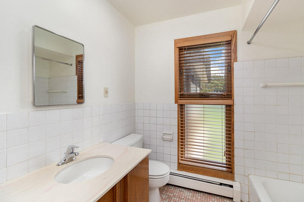 a bathroom with a sink toilet and a window.  Golden Valley, MN Valley View Apartments