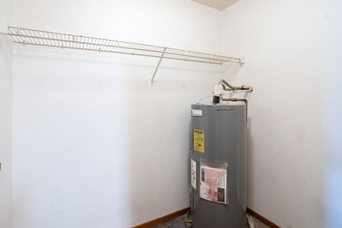 a closet with a water heater and shelves. Fargo, ND Southgate Apartments