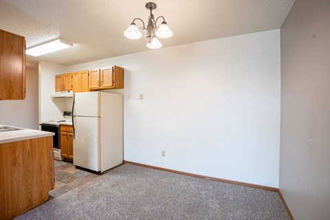A kitchen with a refrigerator, cabinets, and a countertop. Fargo, ND Southgate Apartments