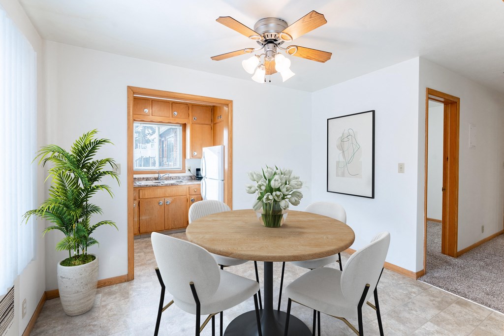 A dining room with a round table and chairs. Fargo, ND L&R Apartments