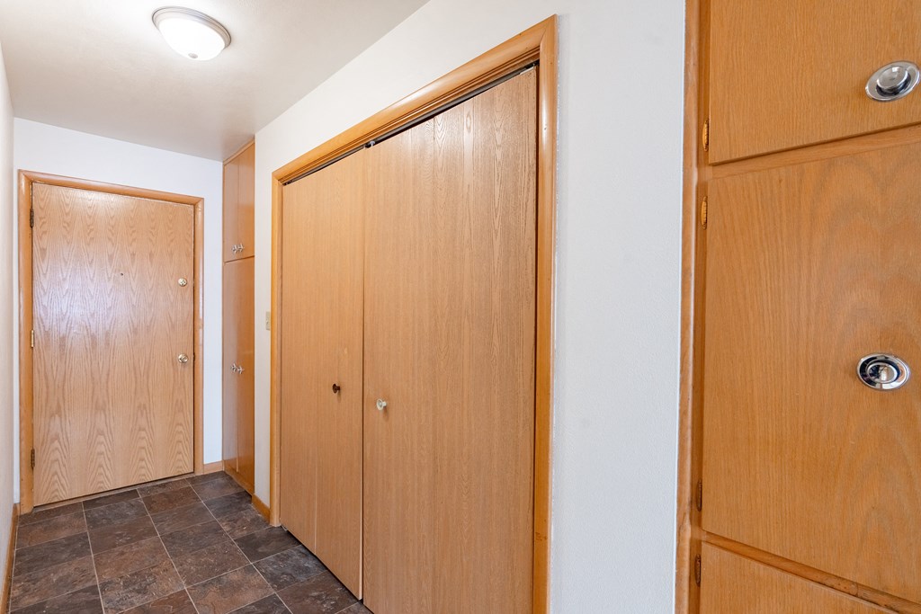 A hallway with three wooden doors. Fargo, ND L&R Apartments