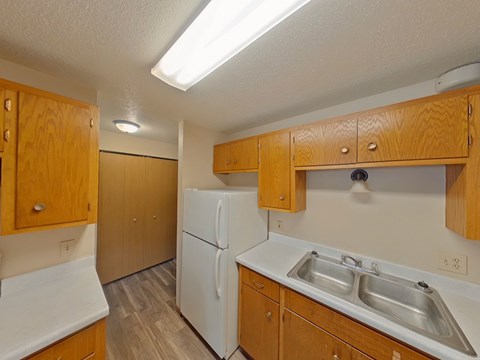 A kitchen with wooden cabinets and a white refrigerator.