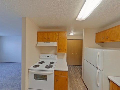 A small kitchen with a white stove and refrigerator.