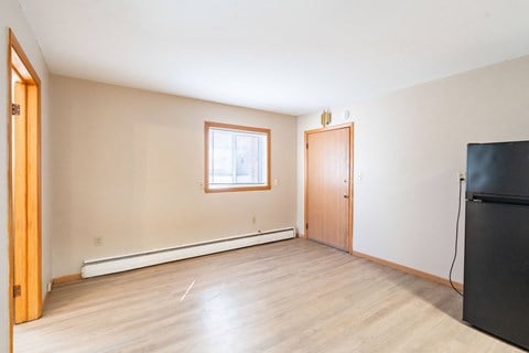A room with a window and a door. Fargo, ND Birchwood Apartments