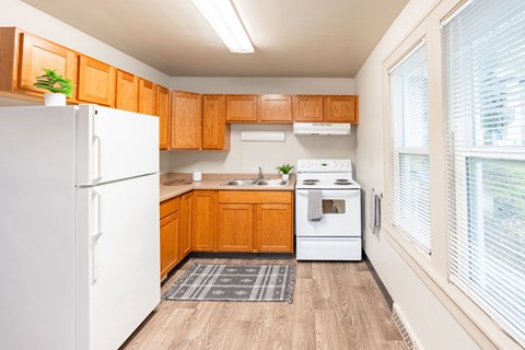 A kitchen with wooden cabinets and a white refrigerator.