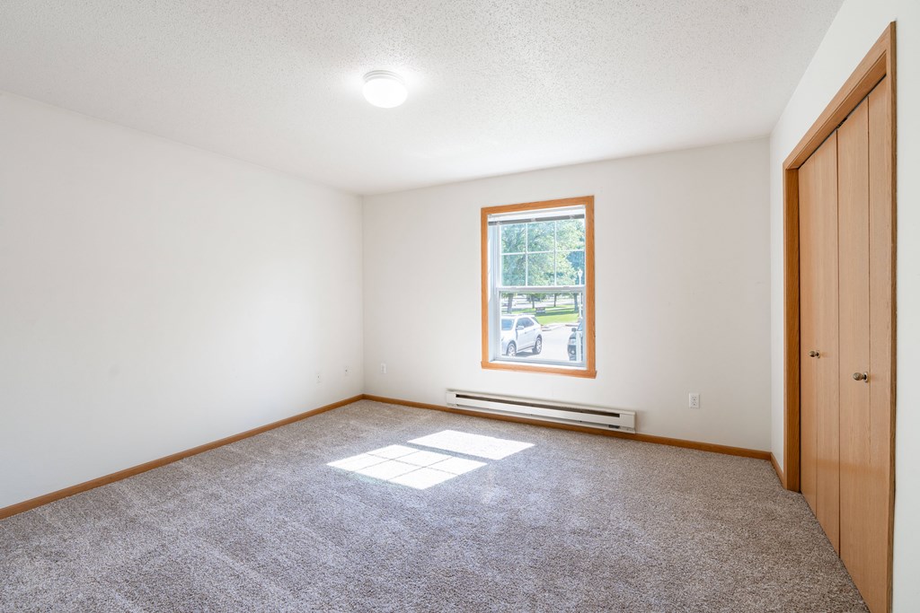 A room with a window and a door. Fargo, ND Stonebridge Apartments