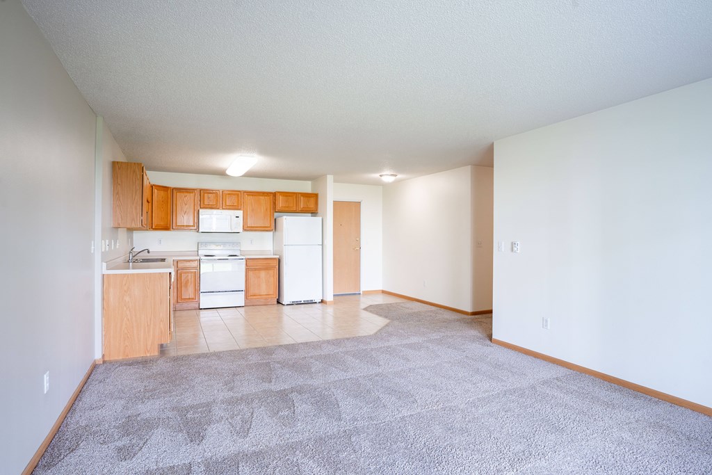 A kitchen with white appliances and wooden cabinets. Fargo, ND Stonebridge Apartments