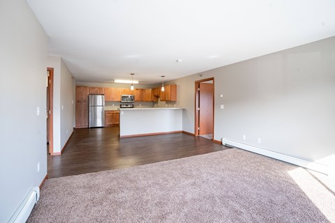 A kitchen with wooden cabinets and a refrigerator is visible.