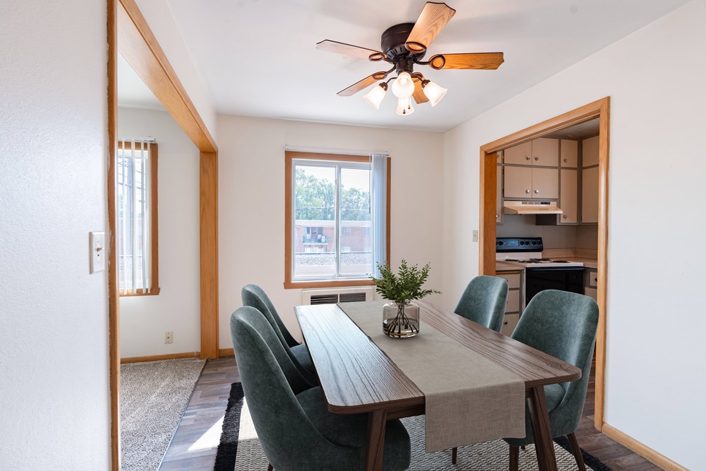 A dining room with a table and chairs. Fargo, ND L&R Apartments