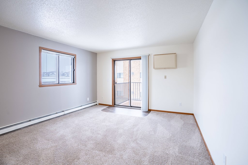 A room with a carpeted floor and a sliding glass door. Fargo, ND Westwood Estates