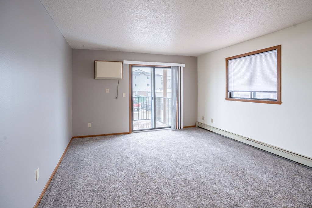 A room with a carpeted floor and a sliding glass door. Fargo, ND Westwood Estates