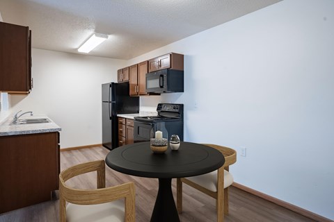 A black table with a vase on it sits in the middle of a kitchen.