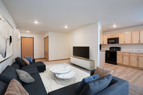 A modern living room with a black couch and a white coffee table.