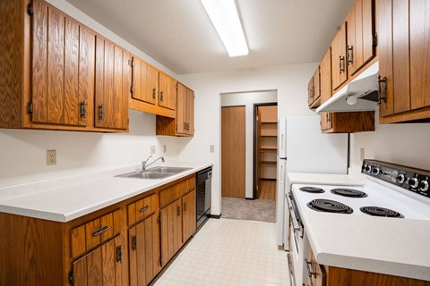A kitchen with wooden cabinets and a white counter top.