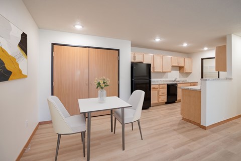 A modern kitchen with a dining table and chairs.