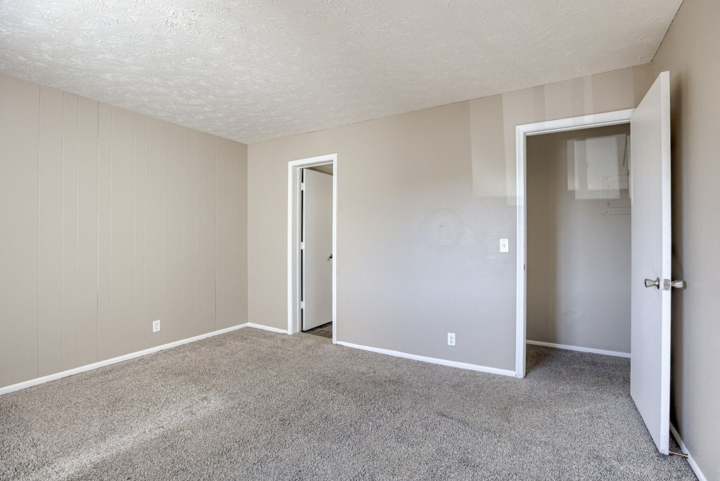 A room with carpeted floor and two doors. Omaha, NE Evergreen Terrace Apartments