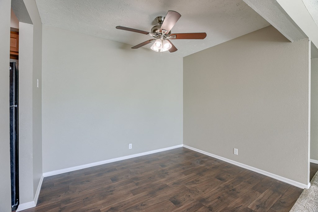 A room with a ceiling fan and wooden flooring. Omaha, NE Evergreen Terrace Apartments