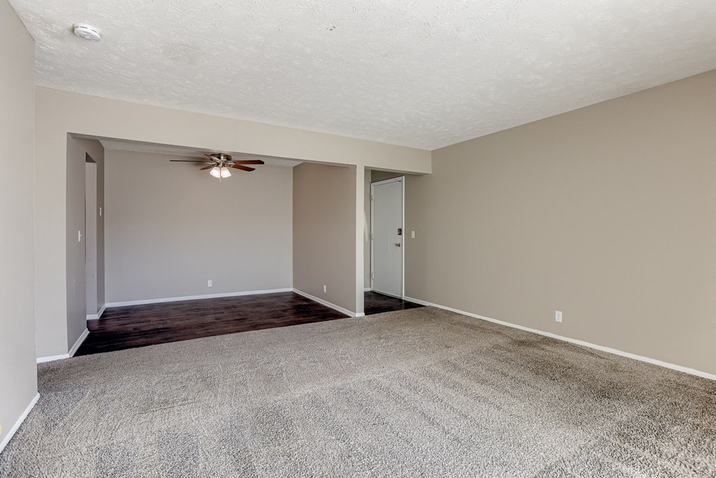 A room with a ceiling fan and carpeted floor. Omaha, NE Evergreen Terrace Apartments