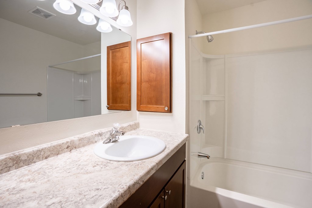 A bathroom with a sink and a mirror. Grand Forks, ND Columbia West Apartments