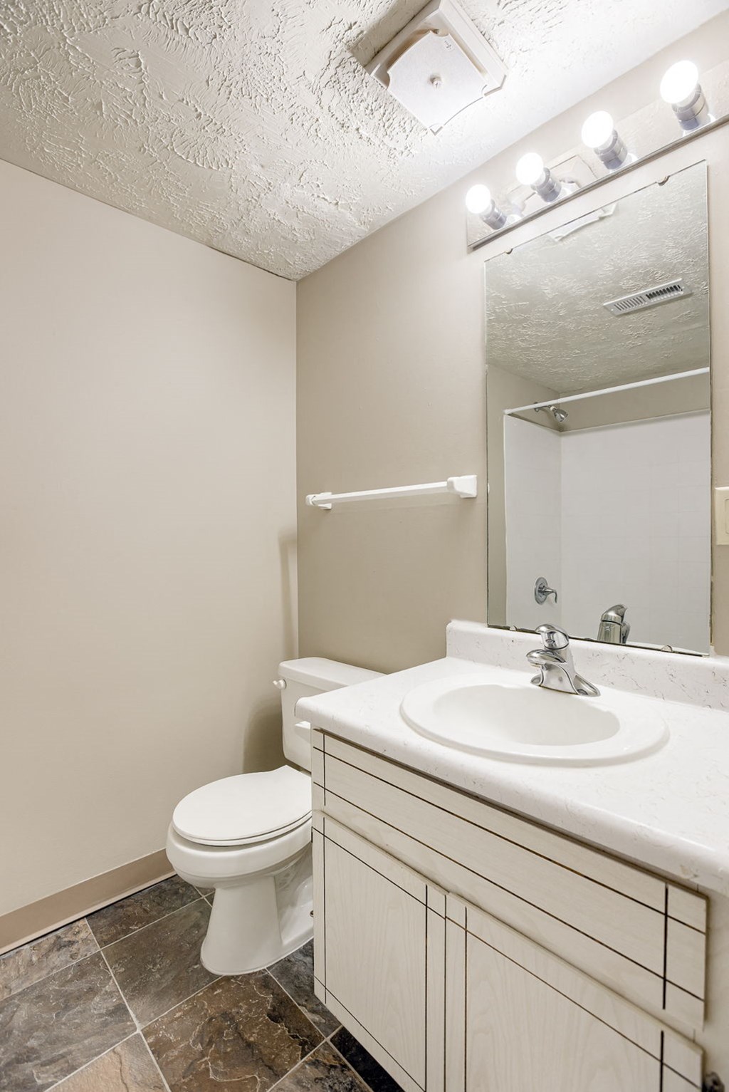 A white toilet sits next to a sink in a bathroom. Omaha, NE Stony Brook Apartments