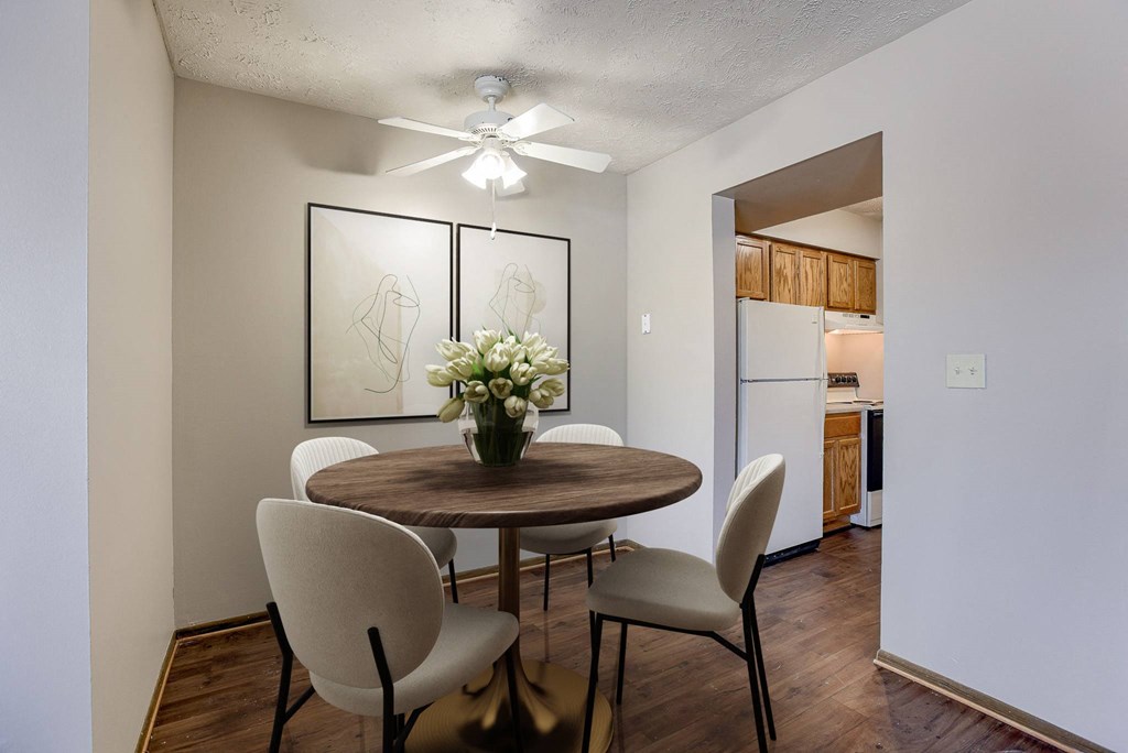 A dining room with a round table and chairs. Omaha, NE Stony Brook Apartments