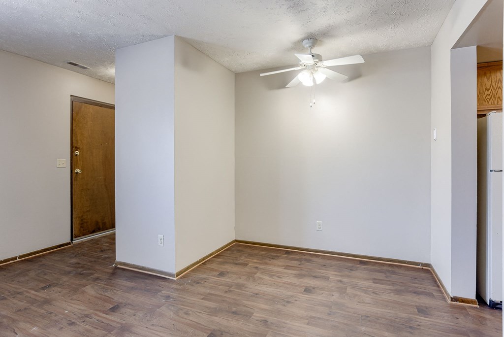 A room with a ceiling fan and a door. Omaha, NE Stony Brook Apartments