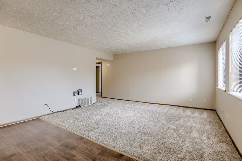 A room with a carpet, wooden floor and a window. Omaha, NE Stony Brook Apartments