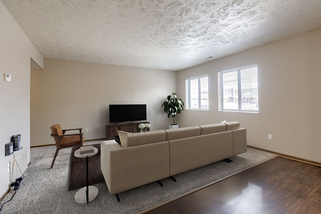 A living room with a couch, chair, and television. Omaha, NE Stony Brook Apartments
