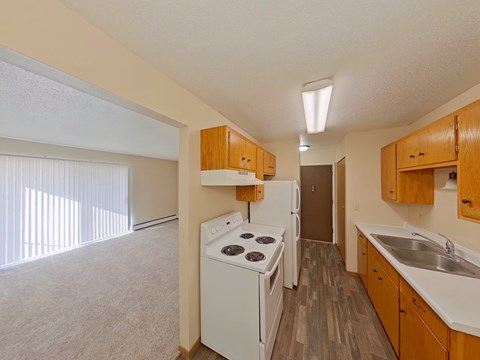 A kitchen with white appliances and wooden cabinets.