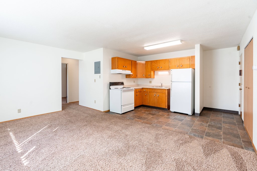 A kitchen with white appliances and wooden cabinets. Fargo, ND Morningside Apartments